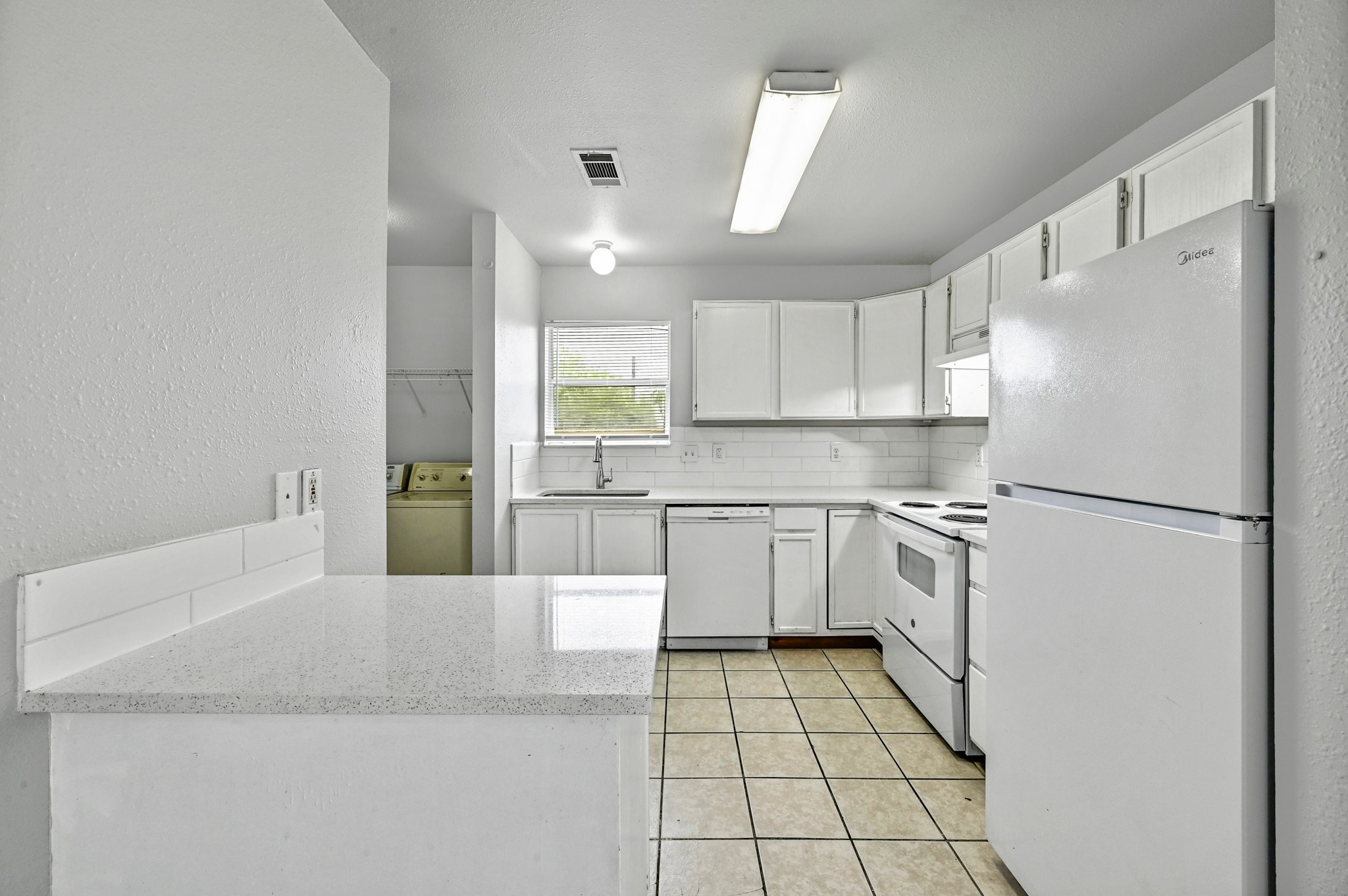 2212 Katy Lane Georgetown, TX 78626 - Photo 11 of 27 The kitchen features white cabinetry, white appliances, and a tiled floor