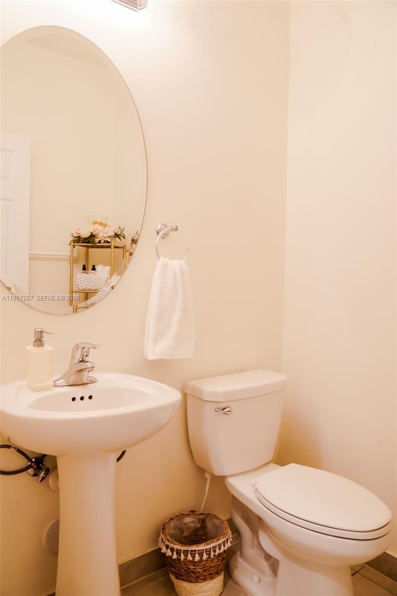 10306 West 33rd Lane Hialeah, FL 33018 - Photo 12 of 29 a bathroom with a sink a toilet and a mirror