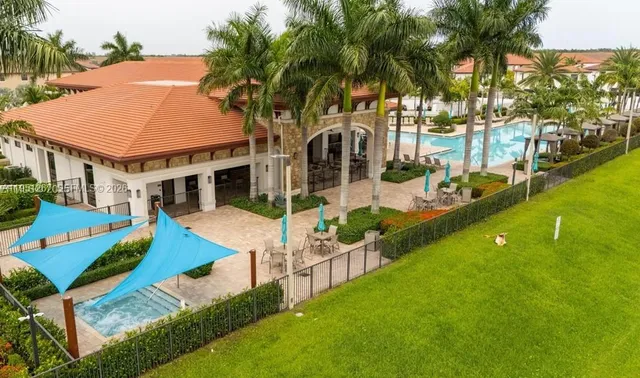 an aerial view of a house with swimming pool and porch