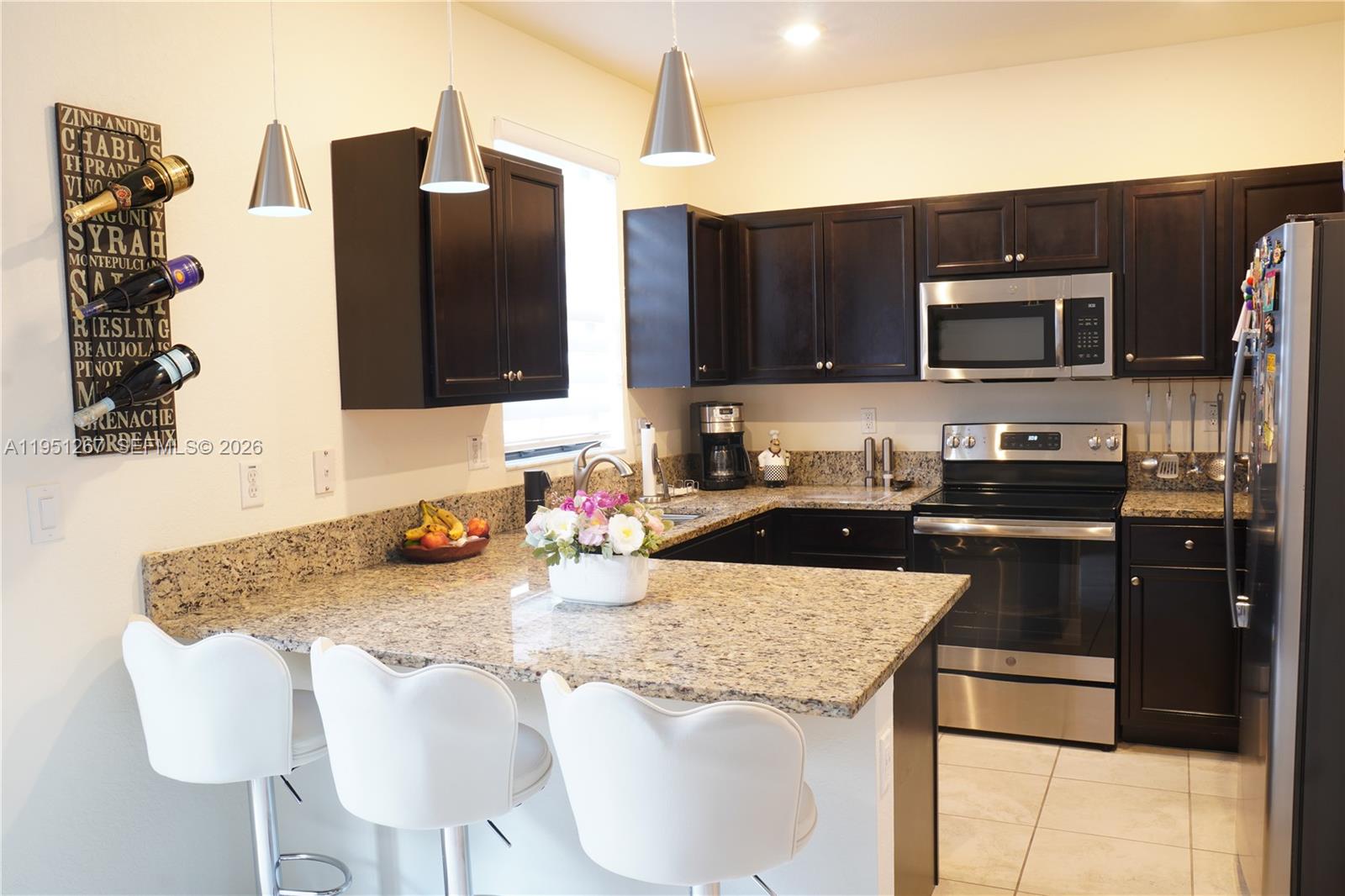 10306 West 33rd Lane Hialeah, FL 33018 - Photo 3 of 29 a kitchen with a refrigerator and a stove top oven
