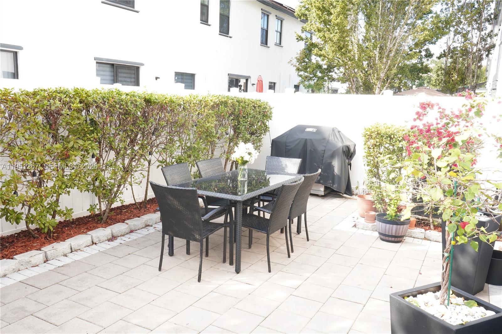 10306 West 33rd Lane Hialeah, FL 33018 - Photo 5 of 29 a view of a patio with table and chairs and potted plants