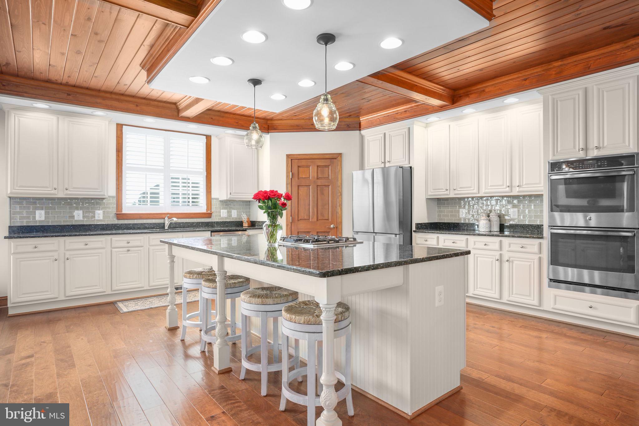 9910 Agnes Lane Spotsylvania, VA 22553 - Photo 22 of 106 a kitchen with stainless steel appliances granite countertop a stove top oven a sink a dining table and chairs with wooden floor
