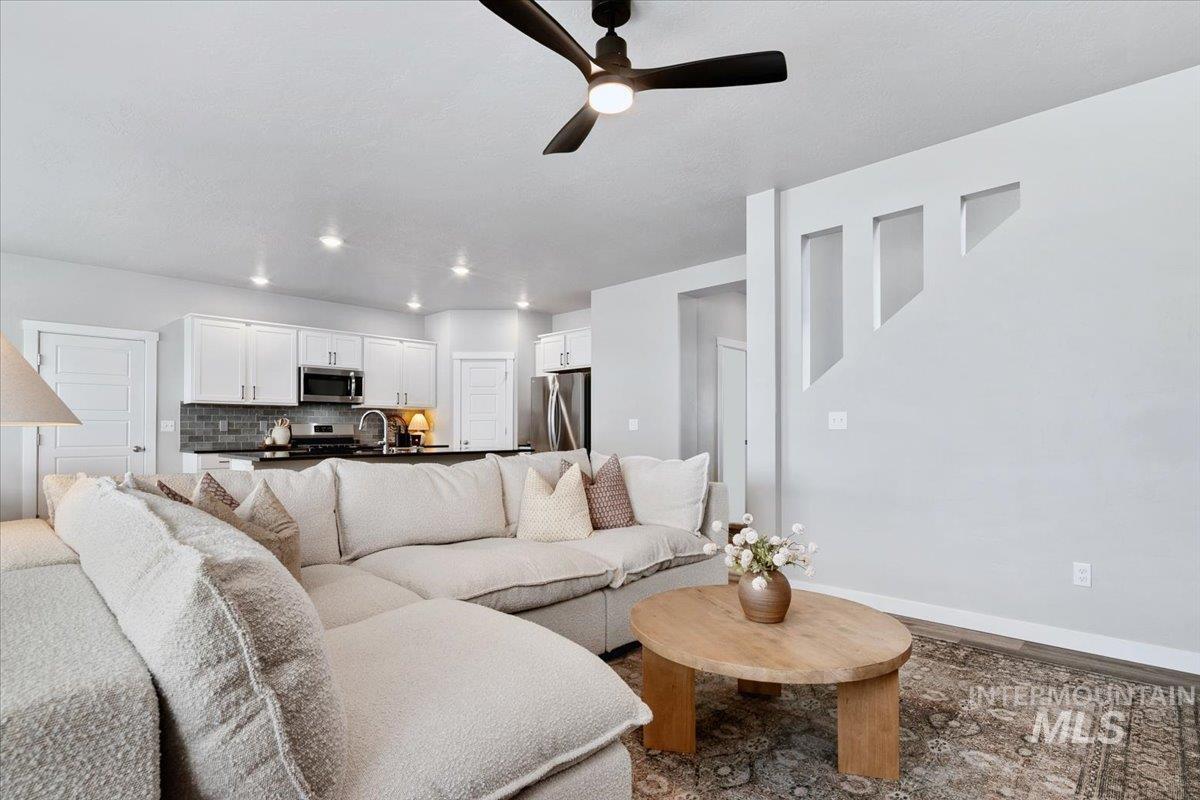 4215 North Pindus Avenue Meridian, ID 83646 - Photo 15 of 46 Living room featuring a ceiling fan, recessed lighting, LVP floors and carpeted u-shaped stairway