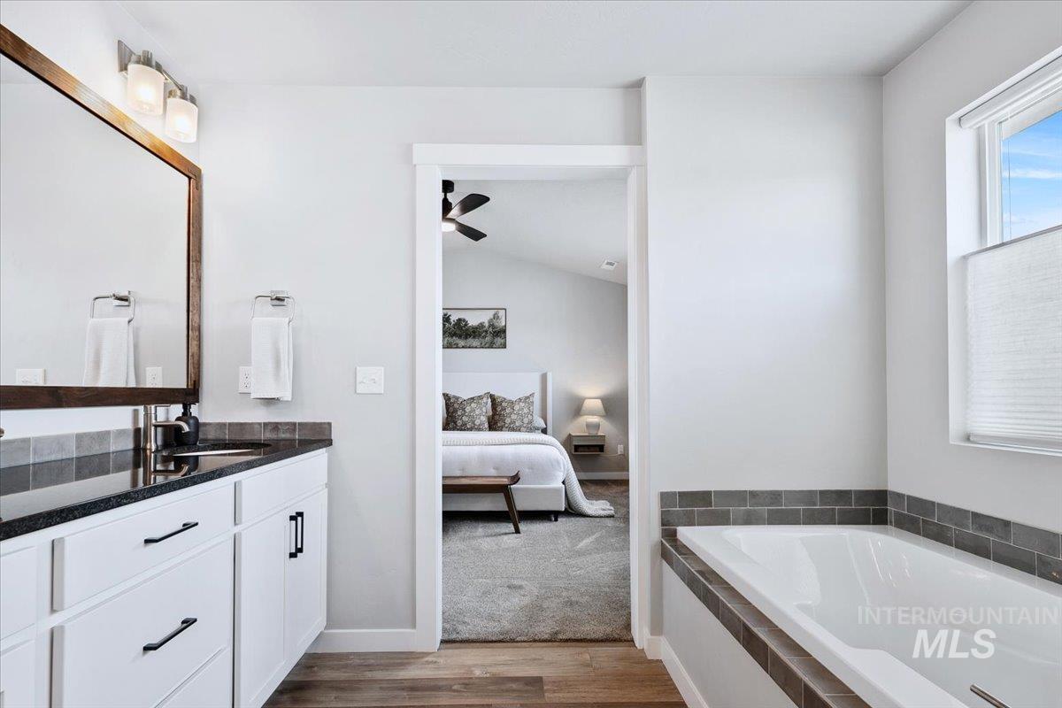 4215 North Pindus Avenue Meridian, ID 83646 - Photo 28 of 46 Bathroom featuring connected bathroom, dual vanity, LVP, water closet and a soaker tub