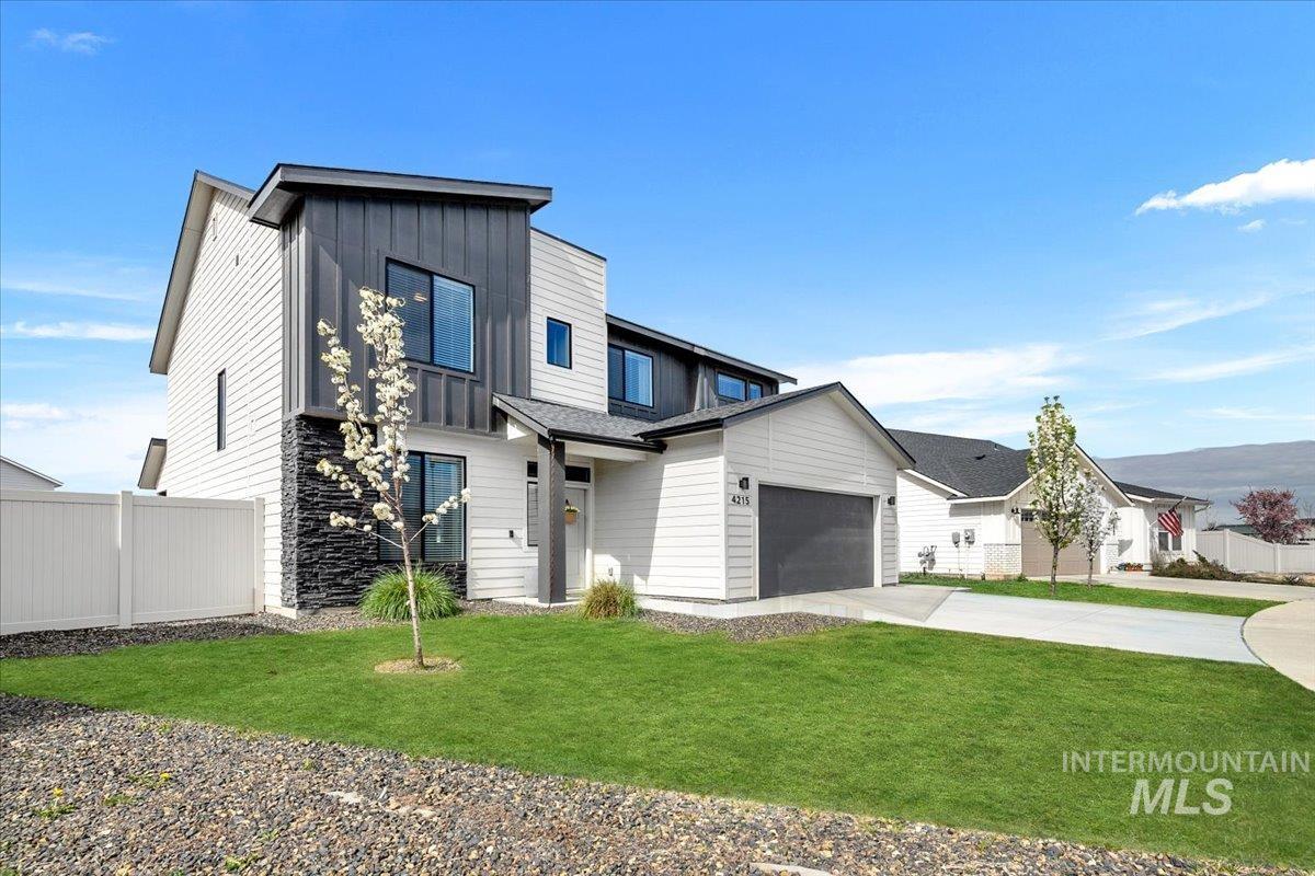 4215 North Pindus Avenue Meridian, ID 83646 - Photo 3 of 46 View of front of property featuring board and batten accents, a 3-car garage and large side yard
