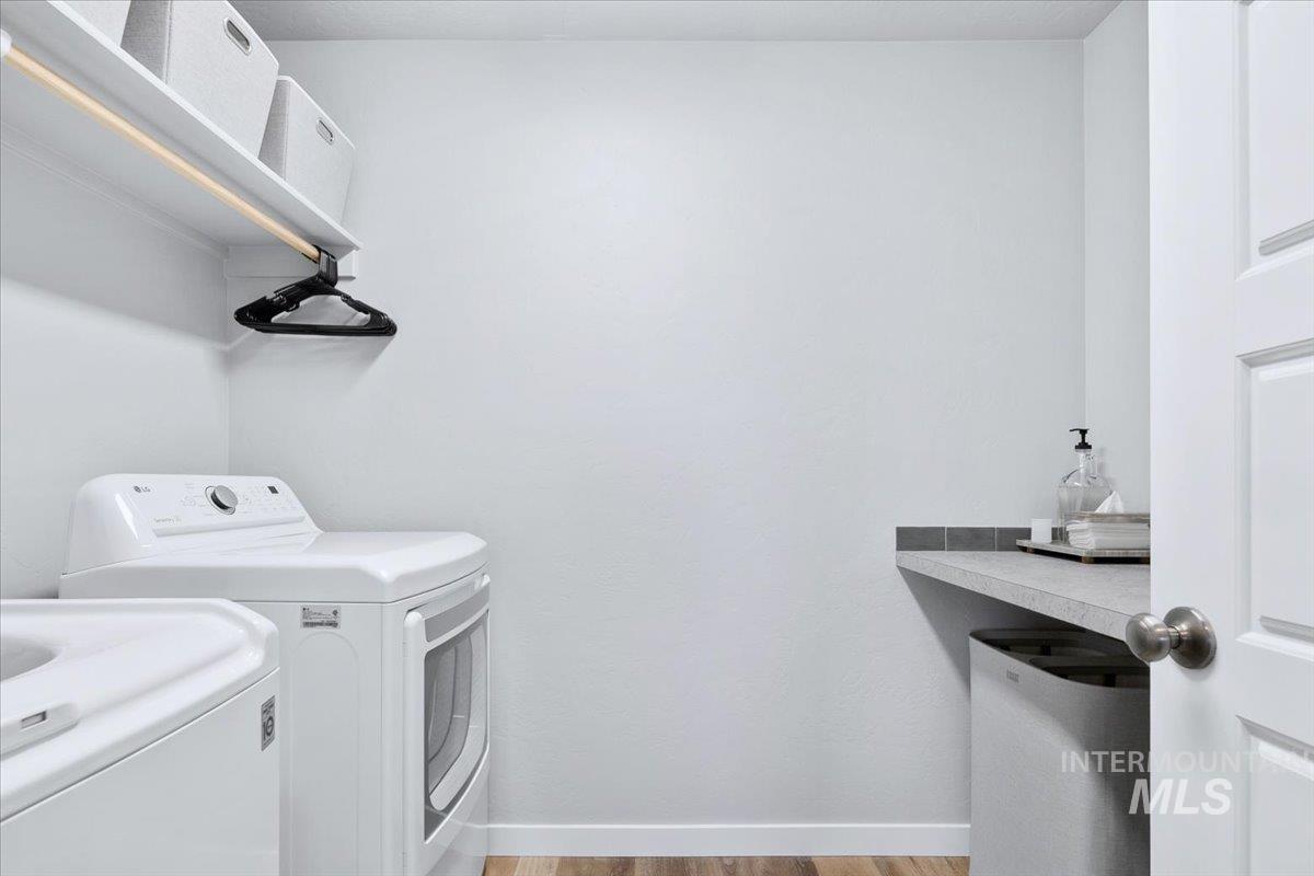 4215 North Pindus Avenue Meridian, ID 83646 - Photo 32 of 46 Laundry area with LVP floors, a folding table and shelves