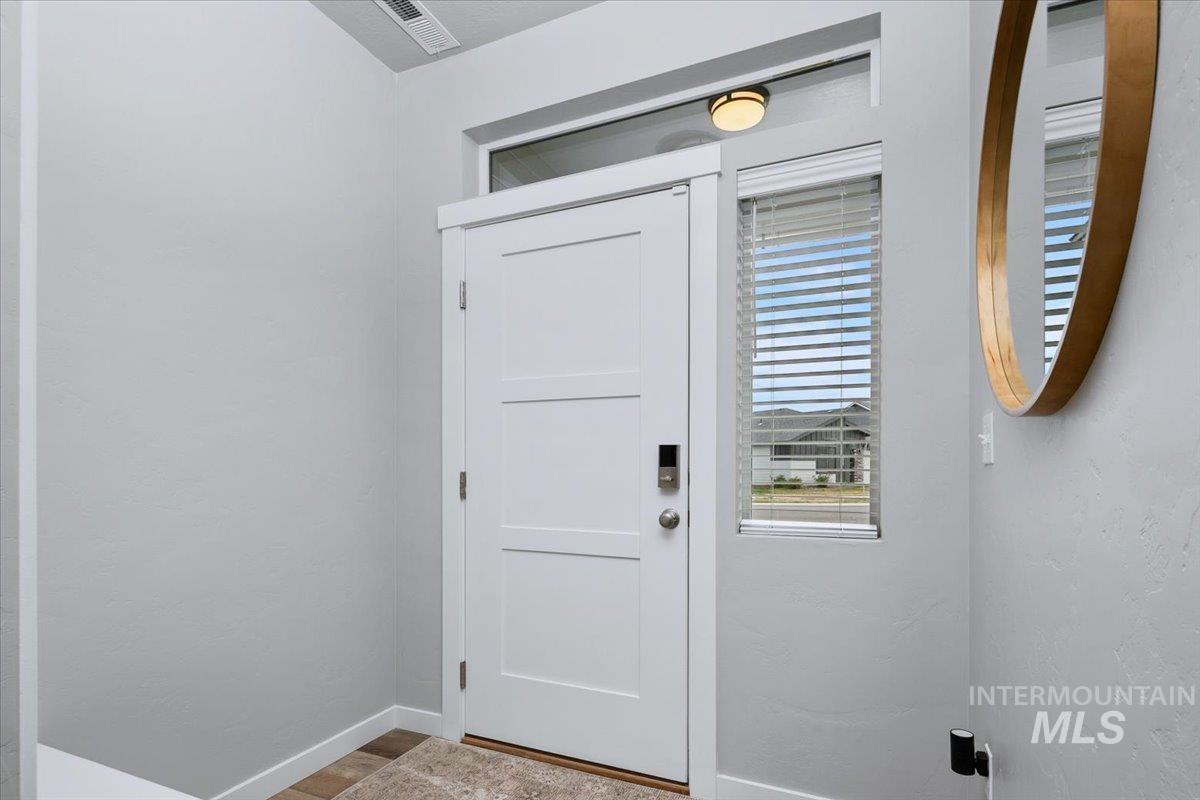 4215 North Pindus Avenue Meridian, ID 83646 - Photo 4 of 46 Doorway with hall bench, keyless entry, and LVP throughout the main floor