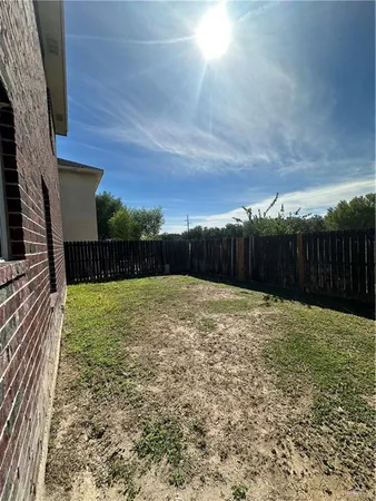 a view of backyard with wooden fence