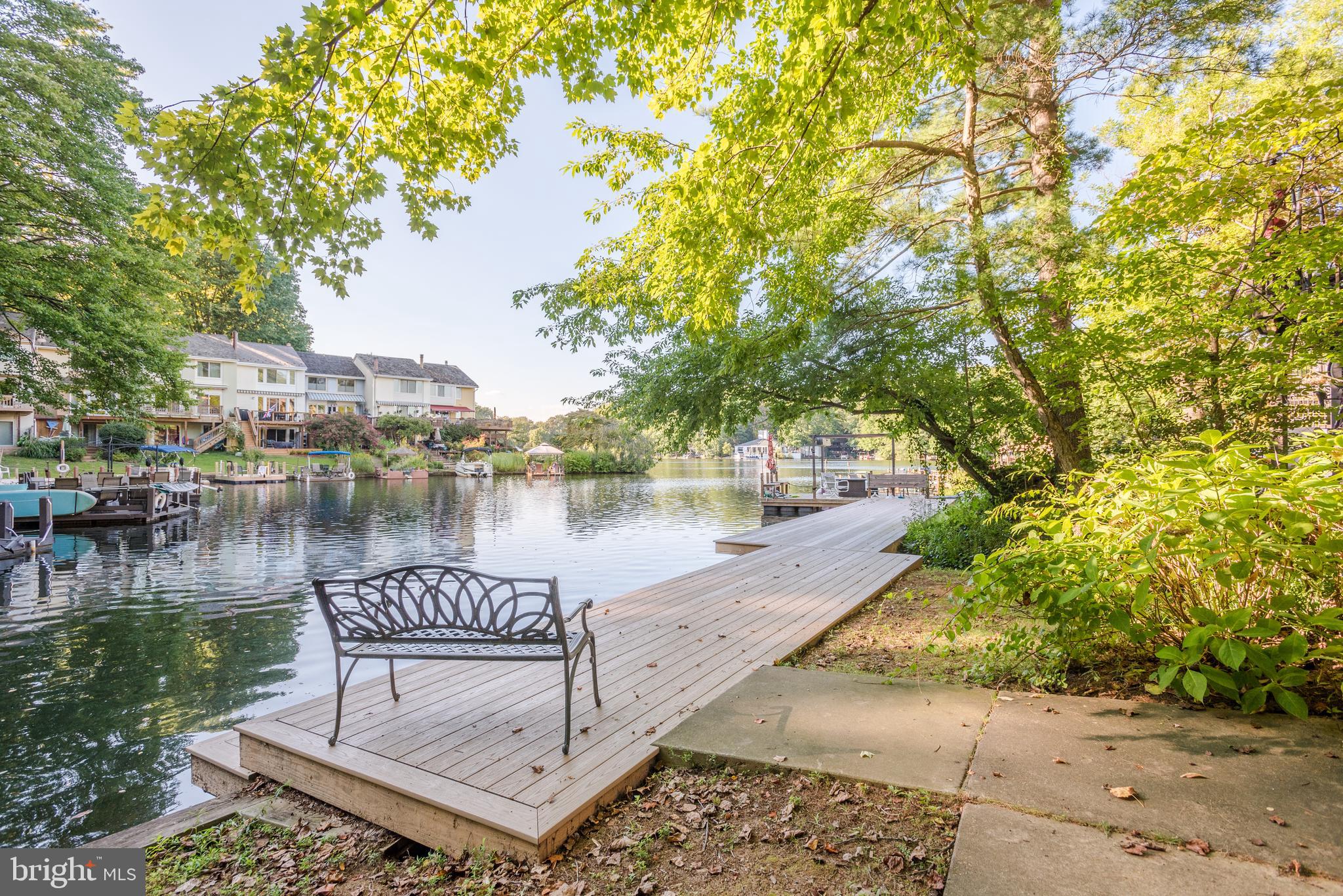 2025 Lakebreeze Way Reston, VA 20191 - Photo 47 of 48 a view of a lake with a bench and trees around