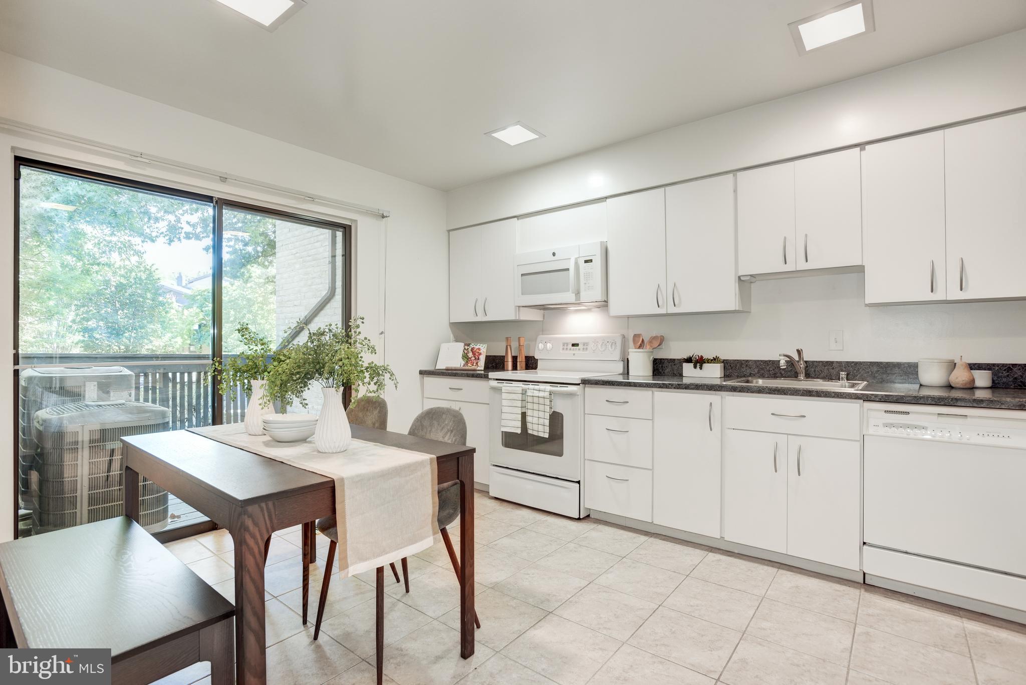 2025 Lakebreeze Way Reston, VA 20191 - Photo 5 of 48 a kitchen with granite countertop white cabinets white stainless steel appliances with a dining table and chairs