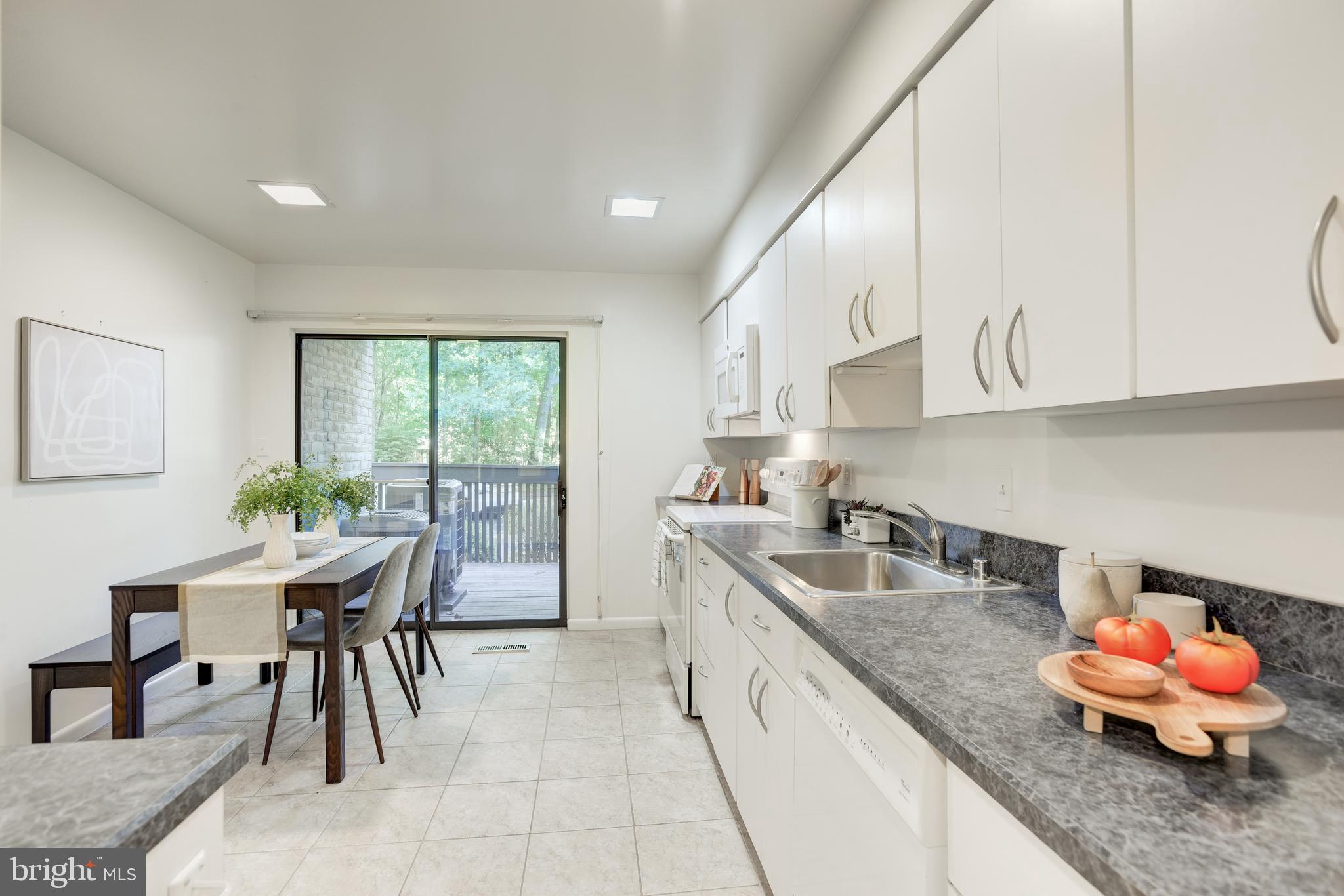 2025 Lakebreeze Way Reston, VA 20191 - Photo 9 of 48 a kitchen with granite countertop a table chairs and a sink