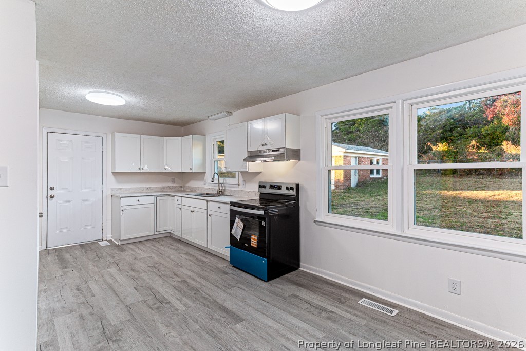 922 Rancho Drive Fayetteville, NC 28303 - Photo 10 of 21 a kitchen with a window wooden floor and stainless steel appliances