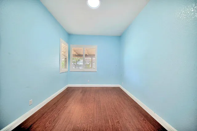 a view of a room with wooden floor and windows