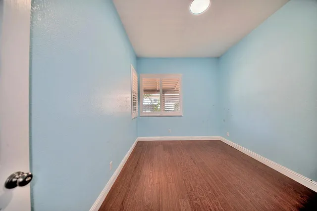 a view of a room with wooden floor and window