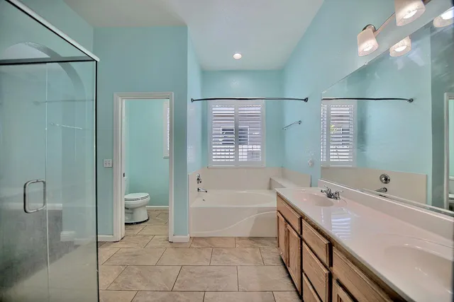 a spacious bathroom with a bathtub sink mirror vanity and toilet