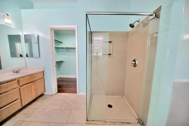 a bathroom with a tub shower sink and mirror