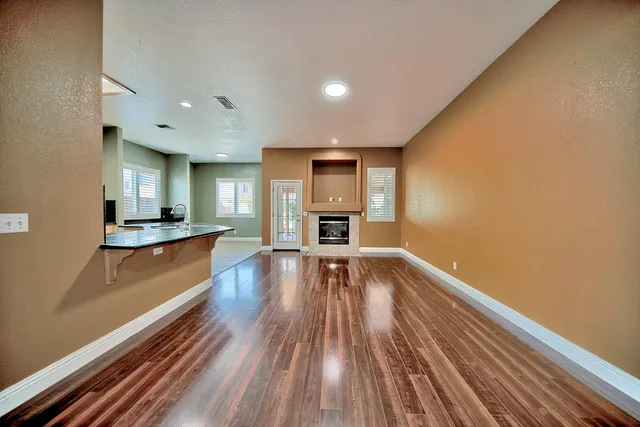 a view of a kitchen with kitchen island wooden floor and stainless steel appliances
