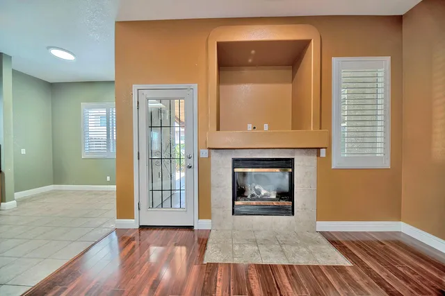 a view of a livingroom with wooden floor and a fireplace
