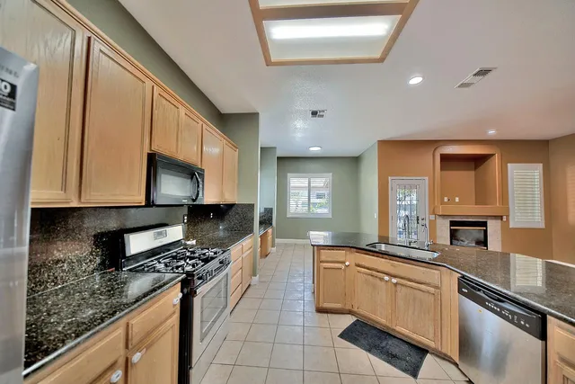 a kitchen with granite countertop a sink stove and cabinets