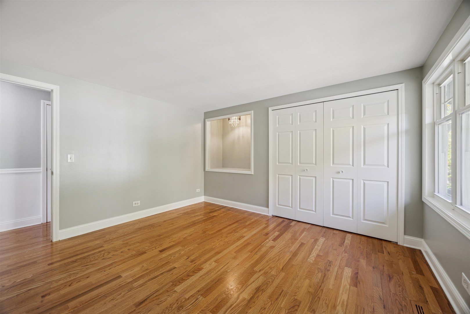 1116 Hidden Spring Drive Naperville, IL 60540 - Photo 20 of 32 an empty room with wooden floor and windows with curtains