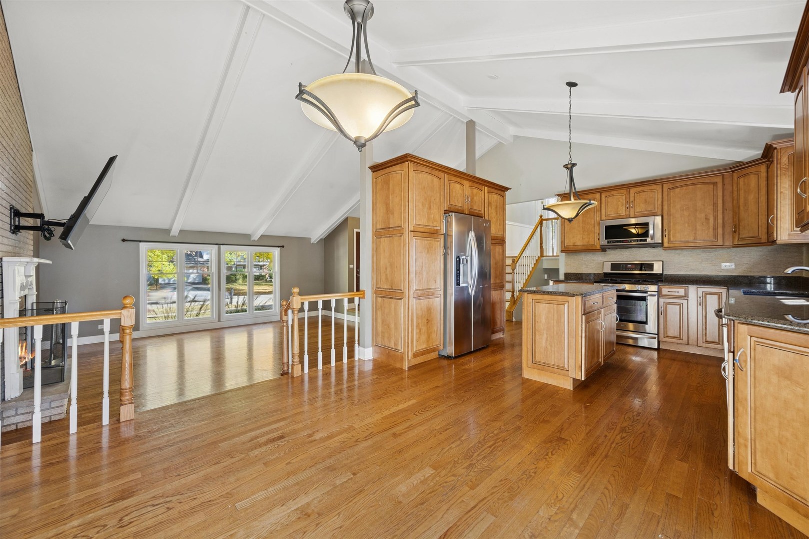 1116 Hidden Spring Drive Naperville, IL 60540 - Photo 3 of 32 a open kitchen with stainless steel appliances granite countertop a stove refrigerator a dining table and chairs with wooden floor
