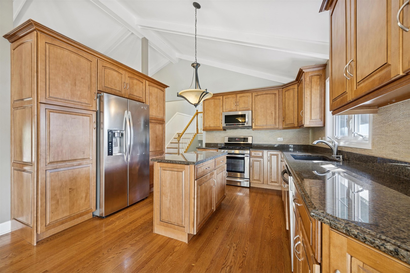 1116 Hidden Spring Drive Naperville, IL 60540 - Photo 4 of 32 a kitchen with granite countertop a refrigerator a sink dishwasher a kitchen island with wooden floor and cabinets