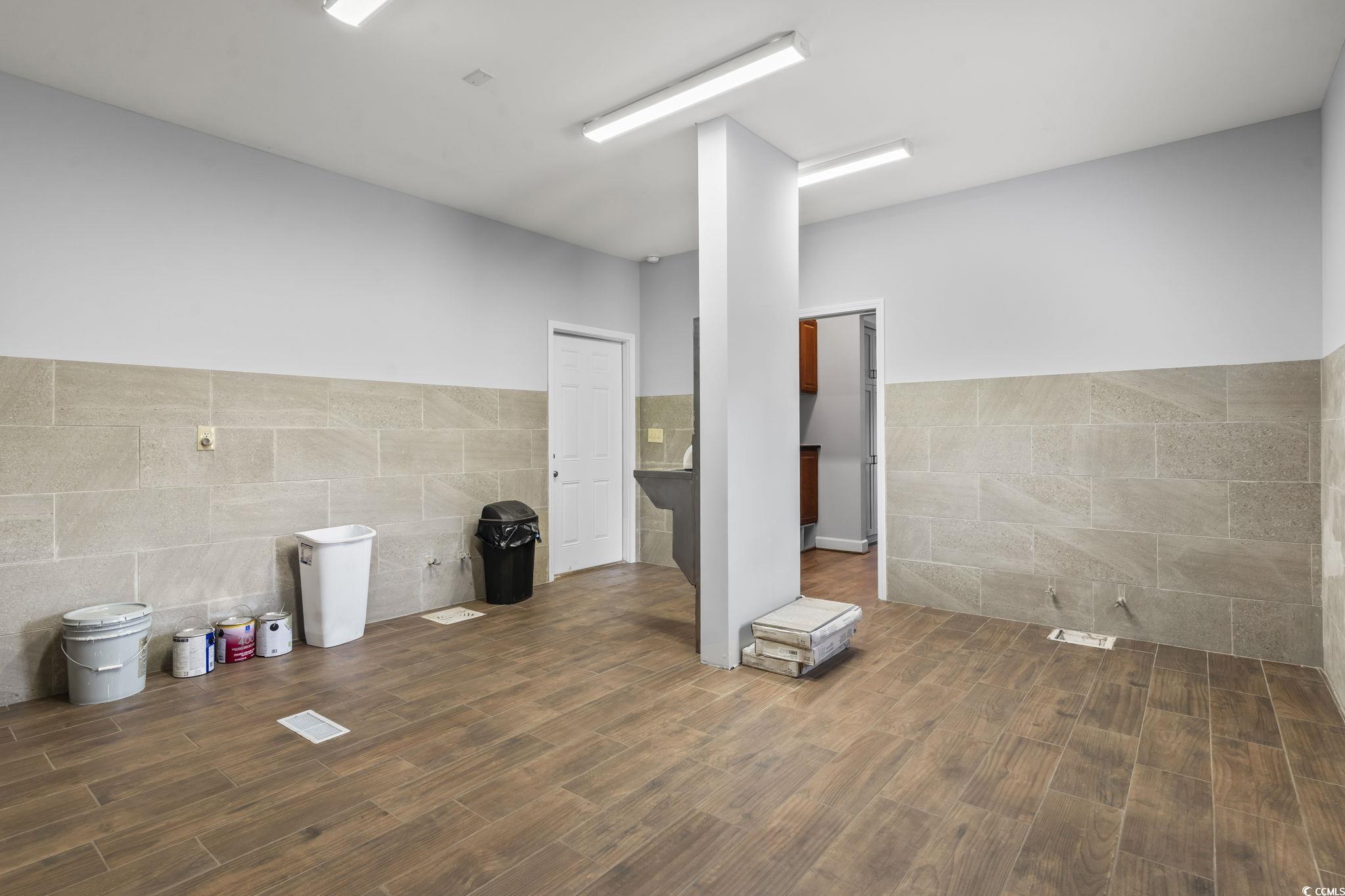 1585 Daisy Road Loris, SC 29569 - Photo 25 of 48 Unfurnished room featuring tile walls, dark wood-style floors, and wainscoting