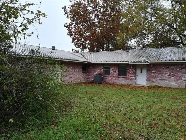 a view of backyard of house with green space