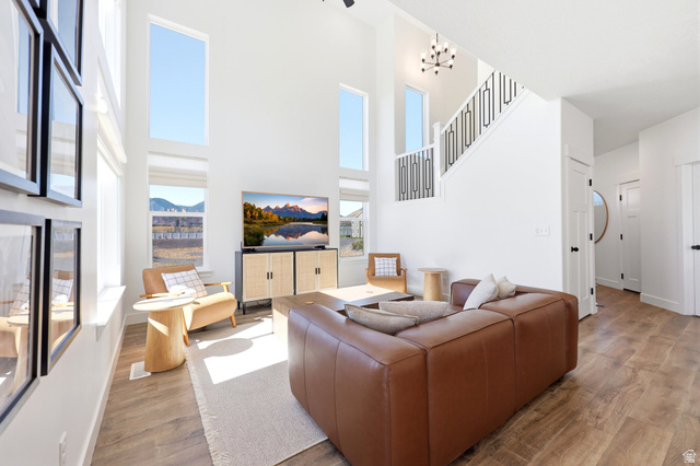 4646 Alder Drive, Unit 223 Mapleton, UT 84664 - Photo 6 of 35 Vaulted living area featuring wood-finish flooring, a contemporary black metal staircase railing, and multiple tall windows