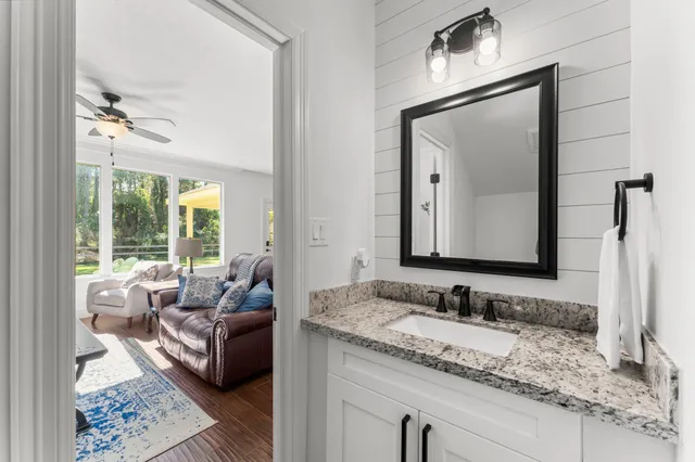 a en suite bathroom with a granite countertop sink and a mirror