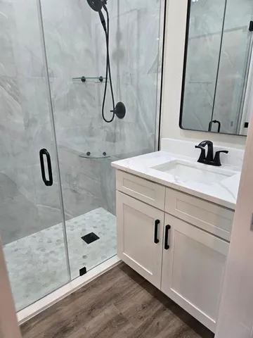 a bathroom with a sink a mirror and shower