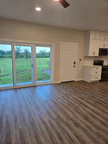 a view of a kitchen with wooden floor and cabinets