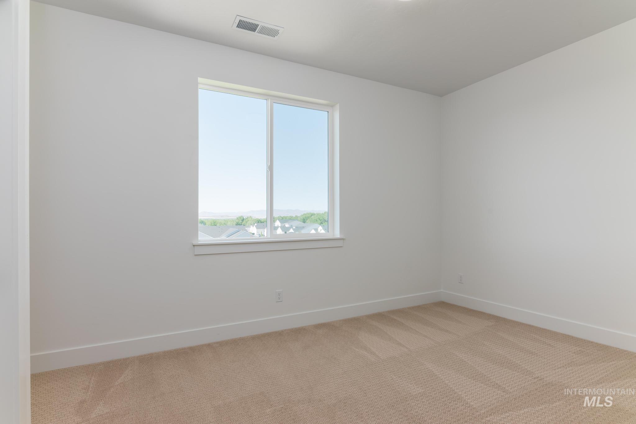 14703 Serenity Pt Street Caldwell, ID 83607 - Photo 25 of 45 Bright room featuring a large window, neutral carpeting, and clean white walls
