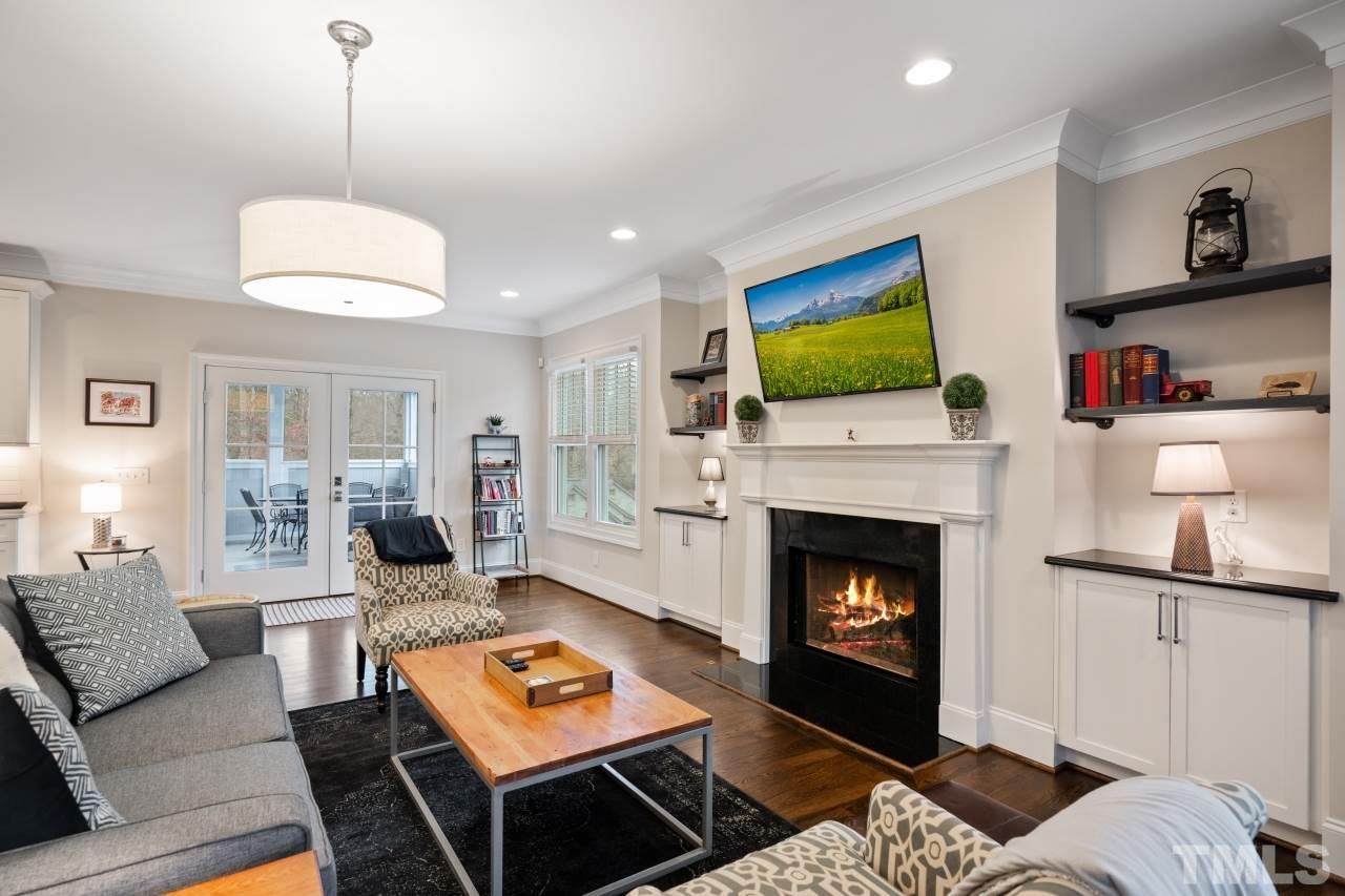 2217 Alexander Road Raleigh, NC 27608 - Photo 14 of 30 a living room with furniture a flat screen tv and a fireplace