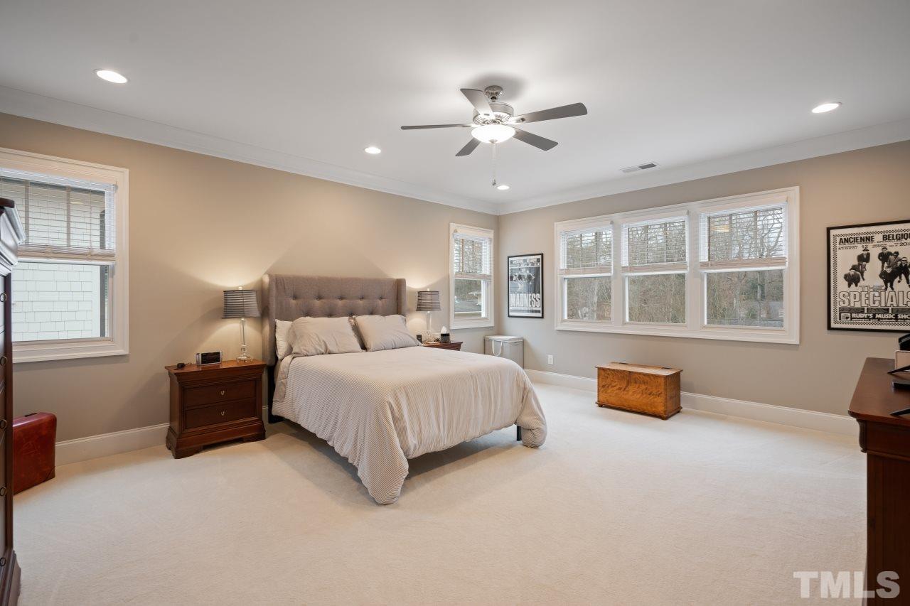 2217 Alexander Road Raleigh, NC 27608 - Photo 19 of 30 a bedroom with a large bed and a chandelier