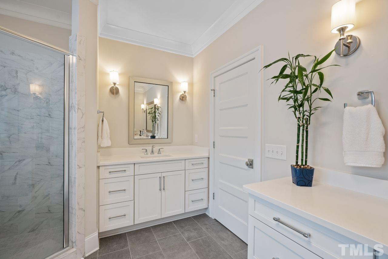 2217 Alexander Road Raleigh, NC 27608 - Photo 20 of 30 a bathroom with a sink a faucet a potted plant and a mirror