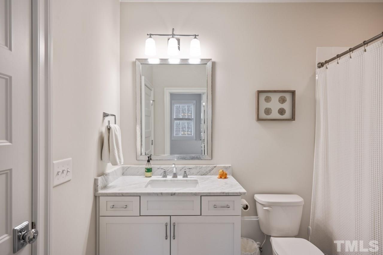 2217 Alexander Road Raleigh, NC 27608 - Photo 26 of 30 a bathroom with a toilet sink and mirror