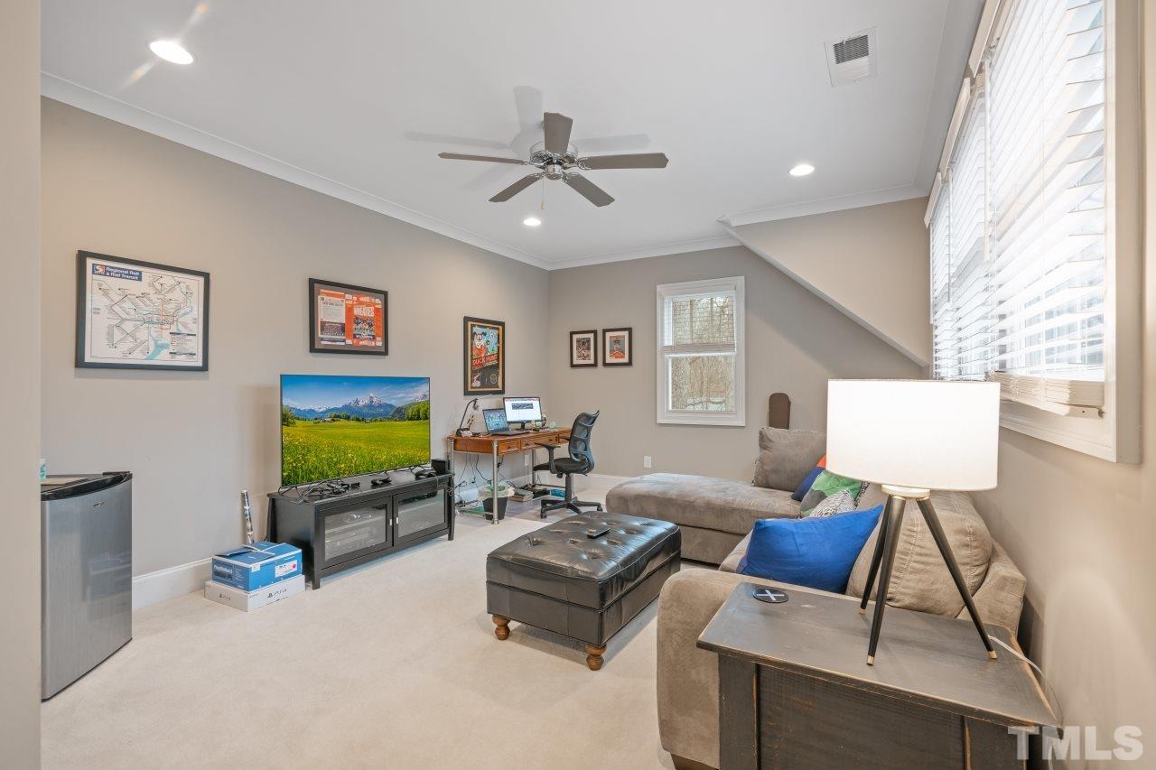 2217 Alexander Road Raleigh, NC 27608 - Photo 28 of 30 a living room with furniture a flat screen tv and a window