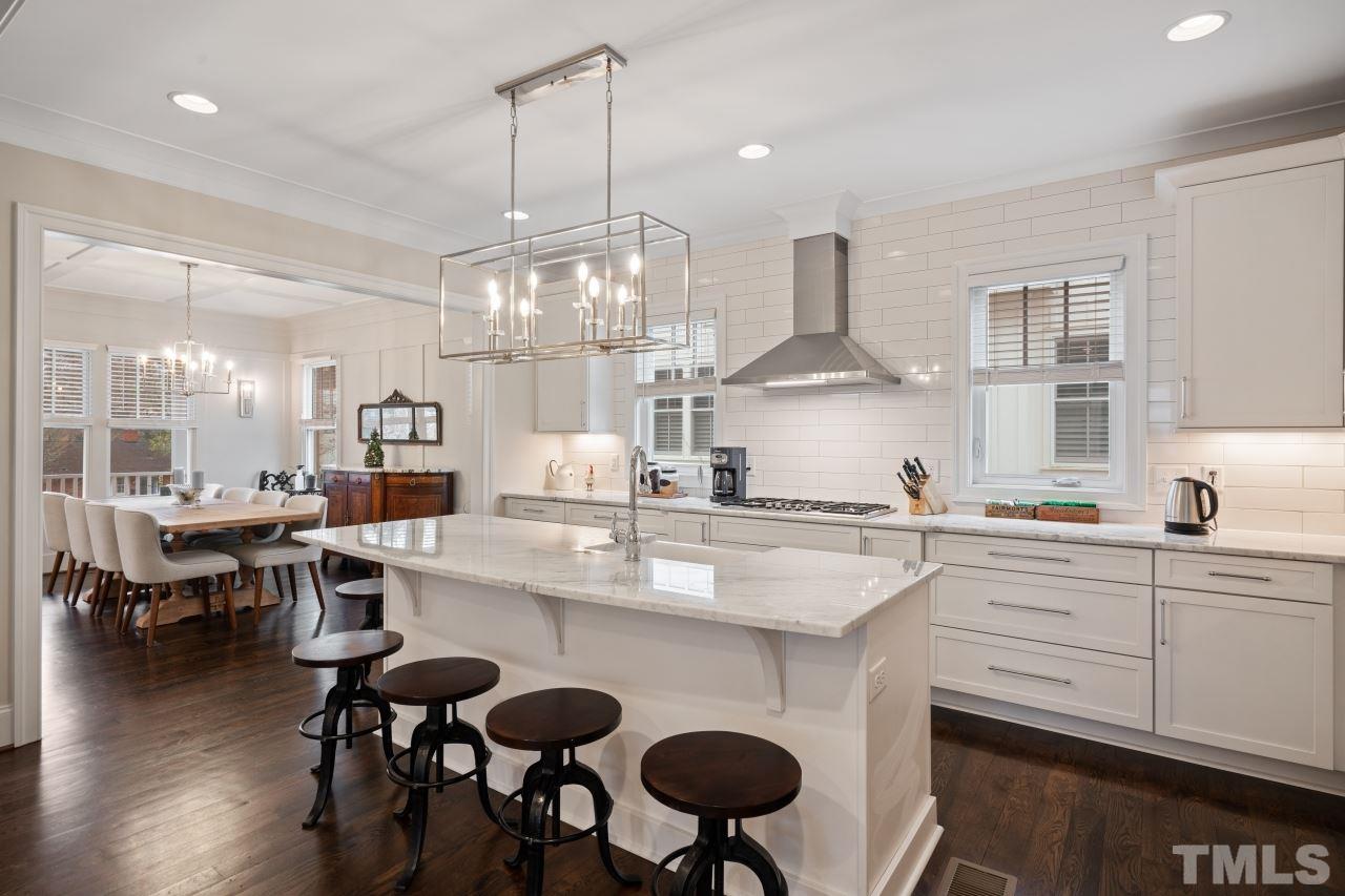 2217 Alexander Road Raleigh, NC 27608 - Photo 7 of 30 a kitchen with stainless steel appliances a table and chairs in it