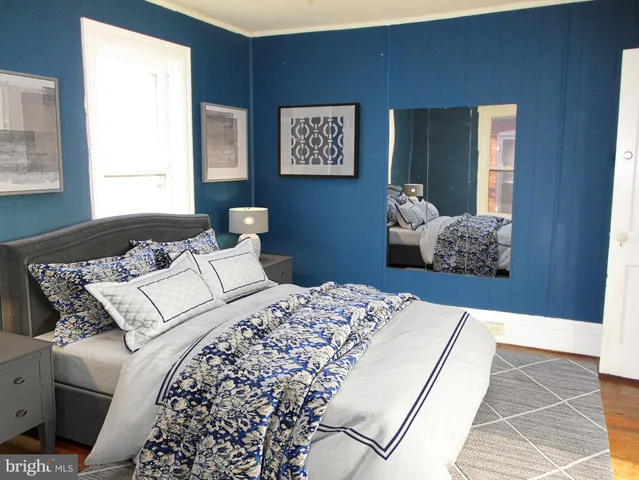 a bedroom with bed and wooden floor