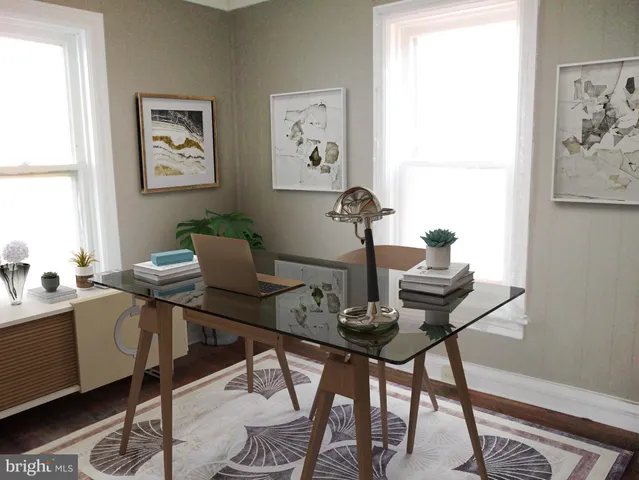 a view of a workspace with furniture and a window