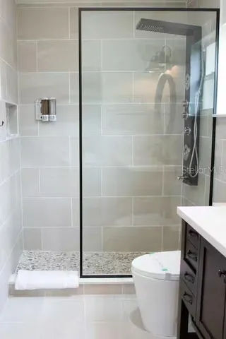 a bathroom with a shower a toilet and a sink