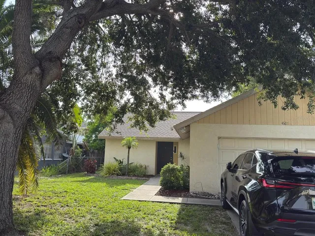 a view of a house with backyard and a tree