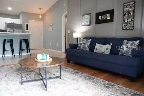 a living room with furniture and a dining table with kitchen view