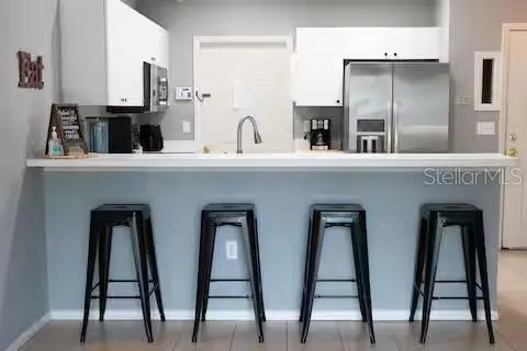 a kitchen with two chairs and two large windows