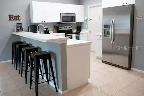 a kitchen with kitchen island a counter top space a sink appliances and cabinets