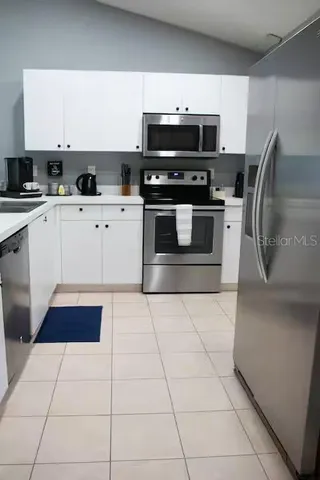 a kitchen with stainless steel appliances a stove a microwave and a sink