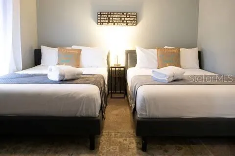 a bed sitting in a bedroom next to a lamp