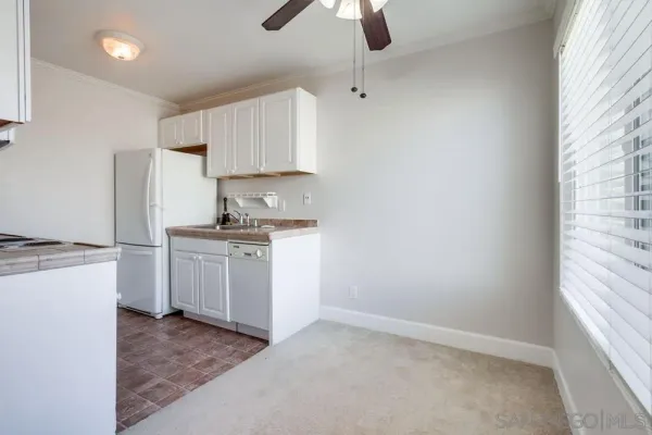 a kitchen with white cabinets and white appliances
