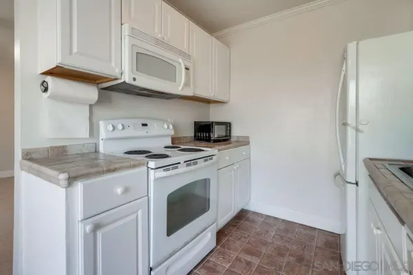 a kitchen with stainless steel appliances granite countertop a stove a microwave and a refrigerator